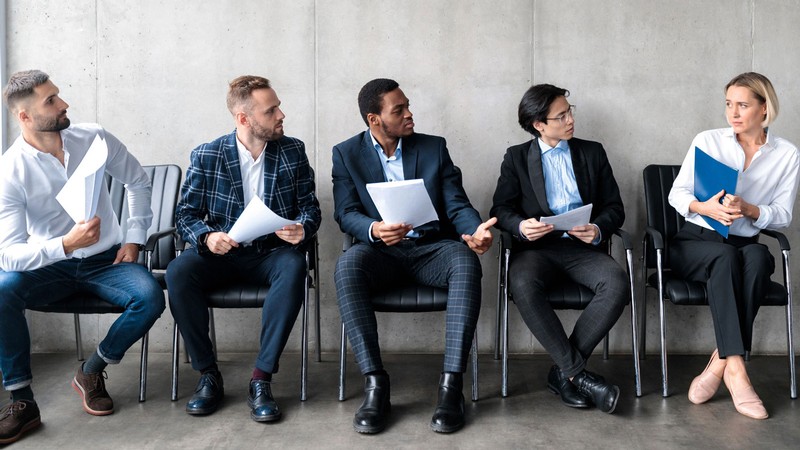 Four men looking skeptically at a woman in a business setting.