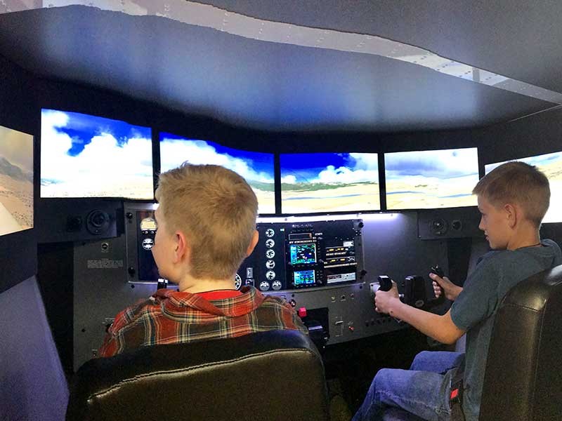 students sitting in flight simulator