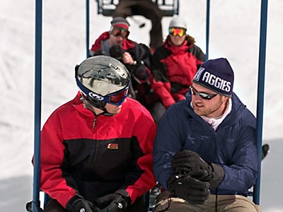 An Aggie skier on a chairlift