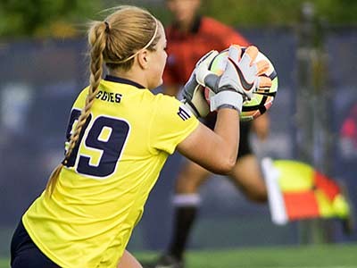 Utah State soccer player on the field with the ball