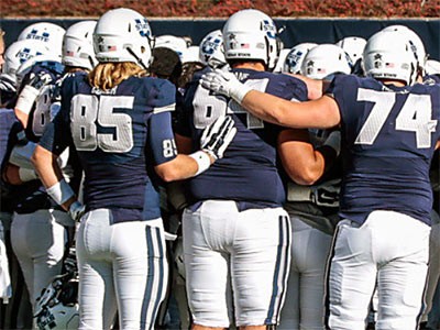Utah State football players in pre-game huddle