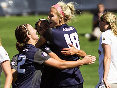 Utah State University soccer players celebrating on the field