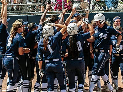 Utah State University softball players on the diamond celebrating