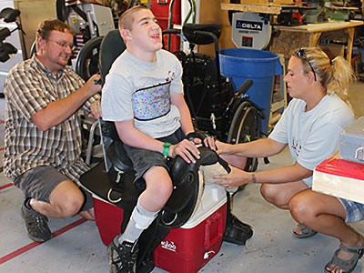 an adapted saddle with client and staff at tje Assistive Technology Center in Roosevelt, Utah