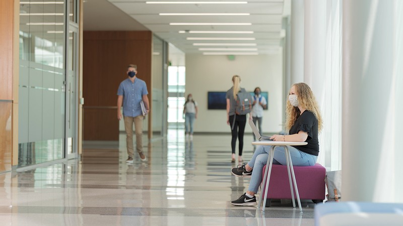 Students walking in a building on USU's campus.