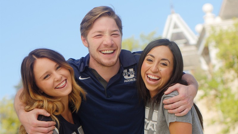 USU students wear Aggie gear below the tower