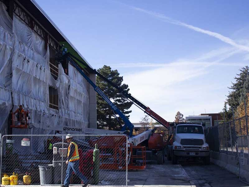 construction worker walking past a building under construction.