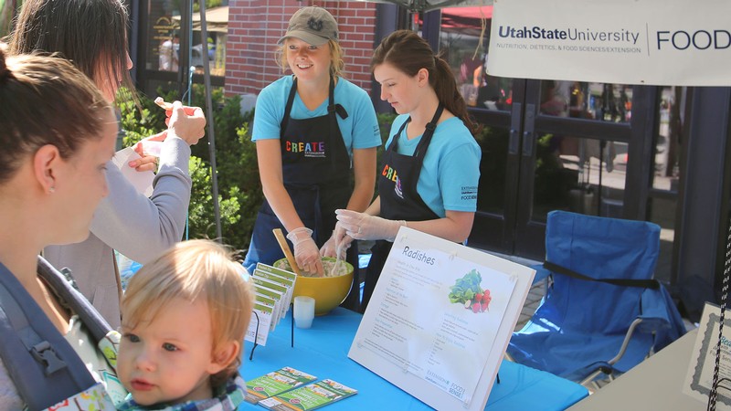 USU students in a booth at a Farmer's Market.