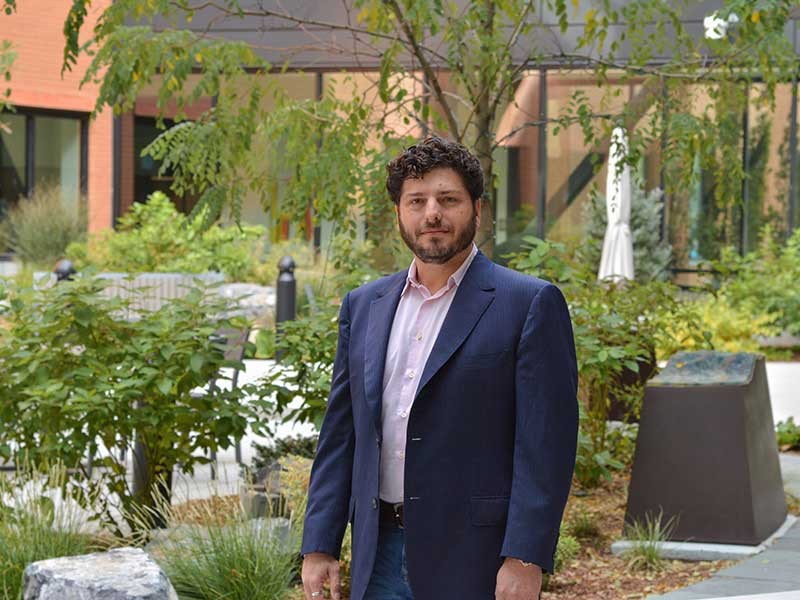 David Feldon standing outside near a garden.