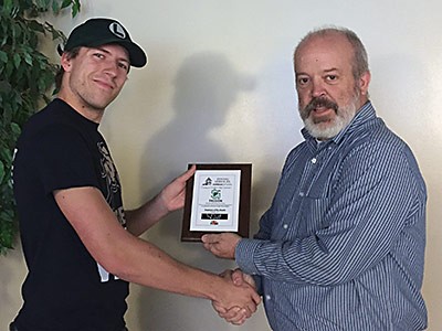 USU Dining Services Executive Director Alan Andersen presenting an award to employee C.J. Tanner