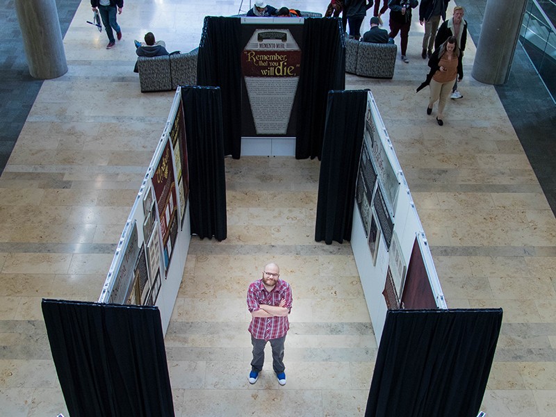Dylan Burns stands next to his exhibit
