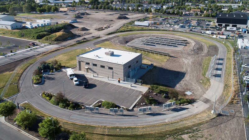 An aerial photograph shows a research facility surrounded by an automotive test track.