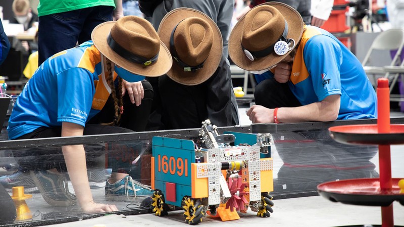 Members of the Team Without a Cool Acronym (TWCA) examine their robot at a FIRST competition.