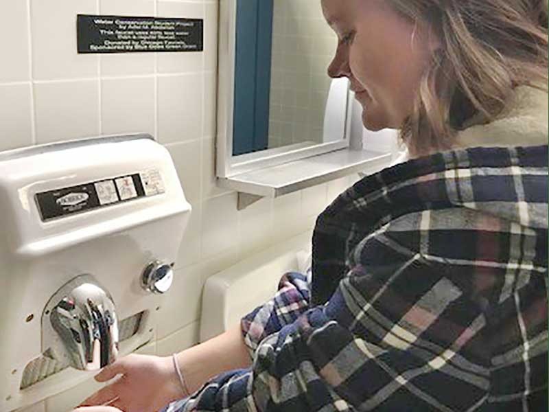 women drying her hands with a hand dryer