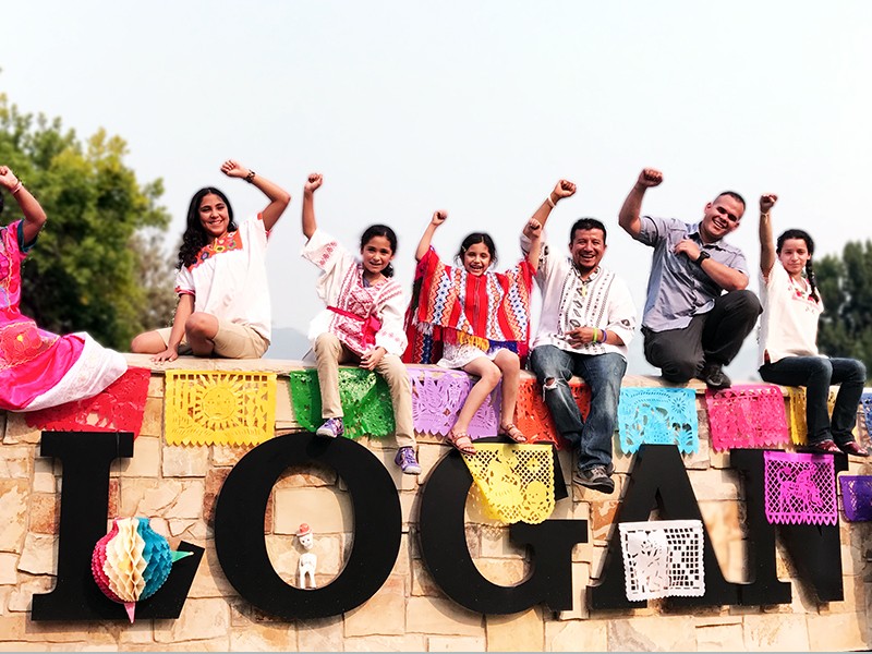 students in costume by Logan sign