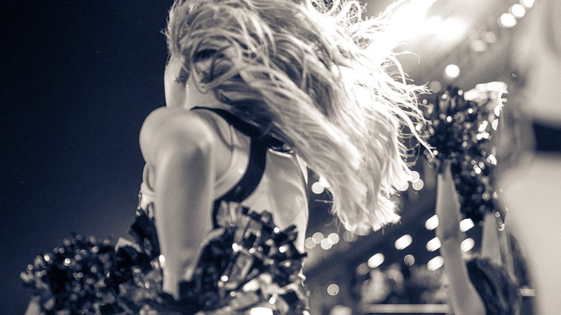 USU cheerleader beneath the stadium lights.