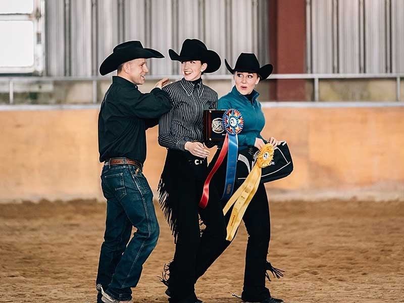 Coach Jason Romney congratulates riders Camille Bethers and Aurora Quinn and Caitlyn Davis
