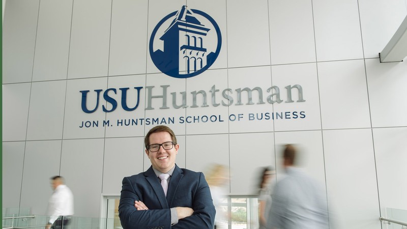 student standing in Huntsman Hall on the USU campus.