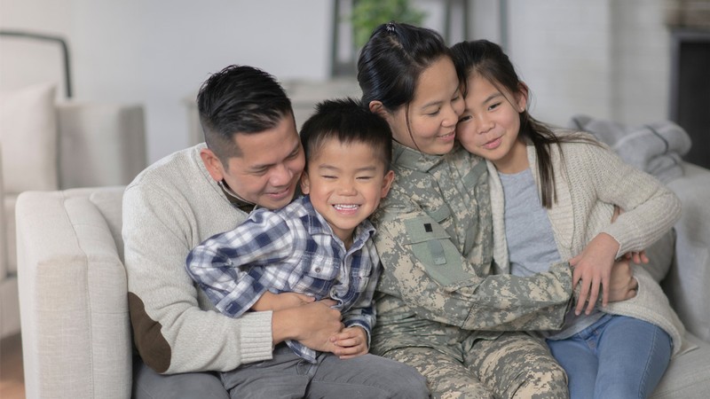 Family with a military mother, gathers together on a couch.