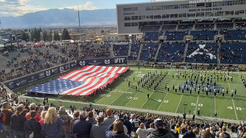 large flag is presented in USU's Maverik Stadium.