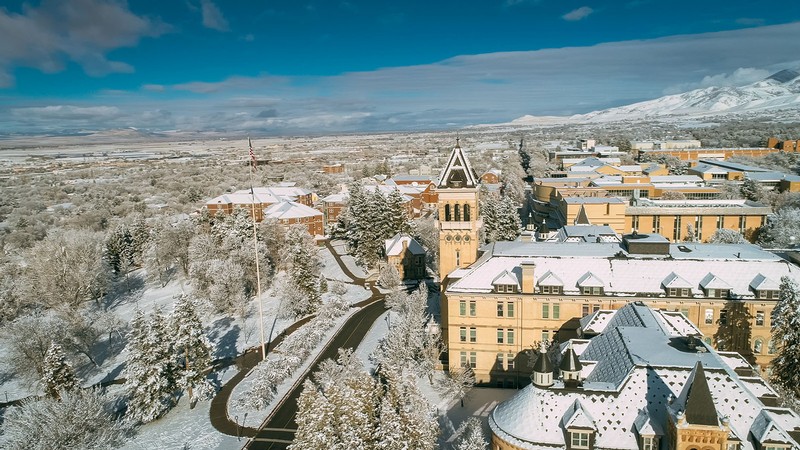 An aerial photograph of Old Main on the USU campus in winter.