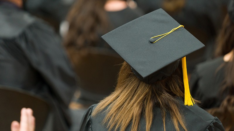 Picture of graduates sitting in a room listening to a speaker