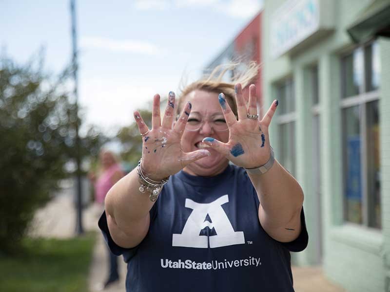 Aggie decked out in Aggie apparel and covered in paint