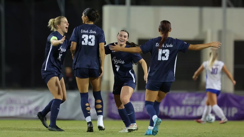Image shows members of USU Women's Soccer coming together in celebration