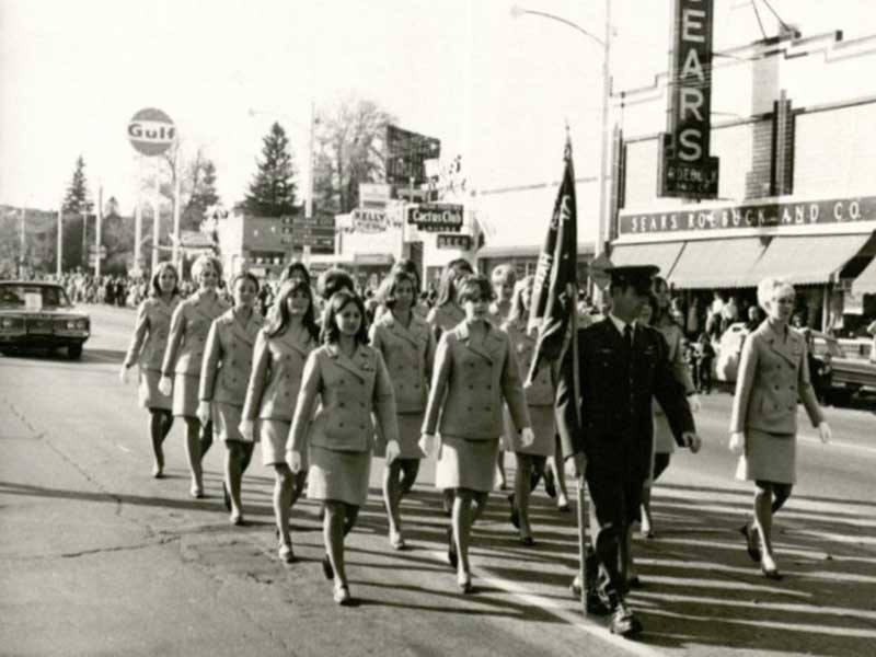 Angel Flight members marching in a parade on Main Street