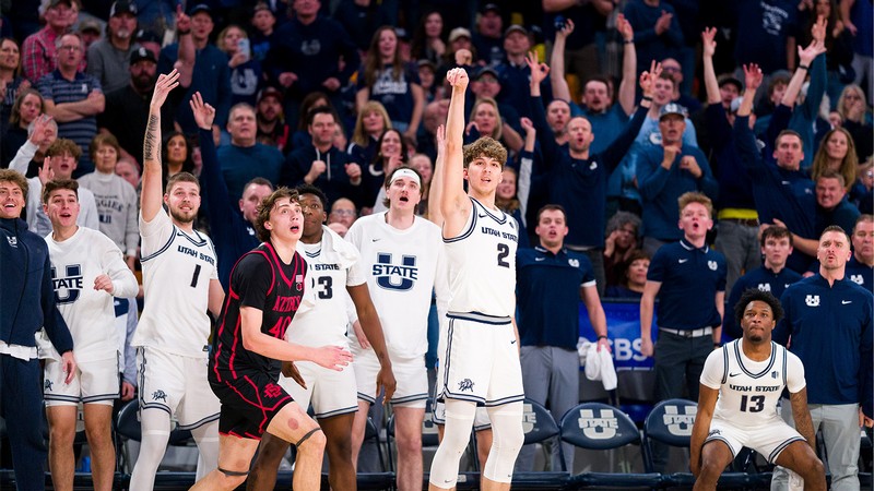 USU Aggie Basketball players and fans watch after one player shoots the ball