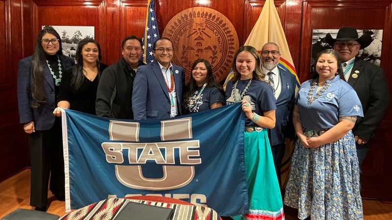 A group of people pose for a photo in an office.