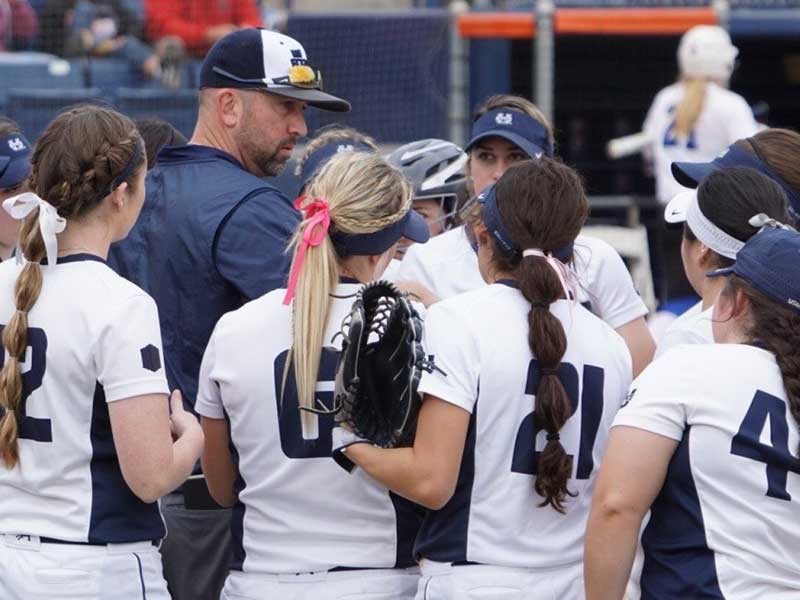 USU softball players gathered in a huddle