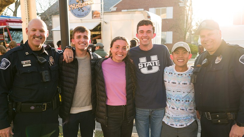 Students pose for a picture with USUPD officers