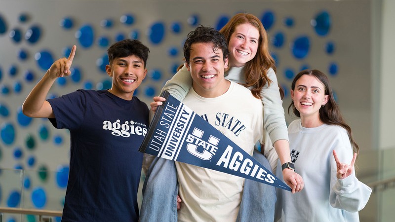 Students posing with Aggie paraphernalia.