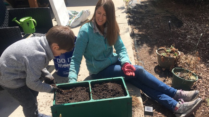 Vonda Jump Norman digging in the dirt with a child.
