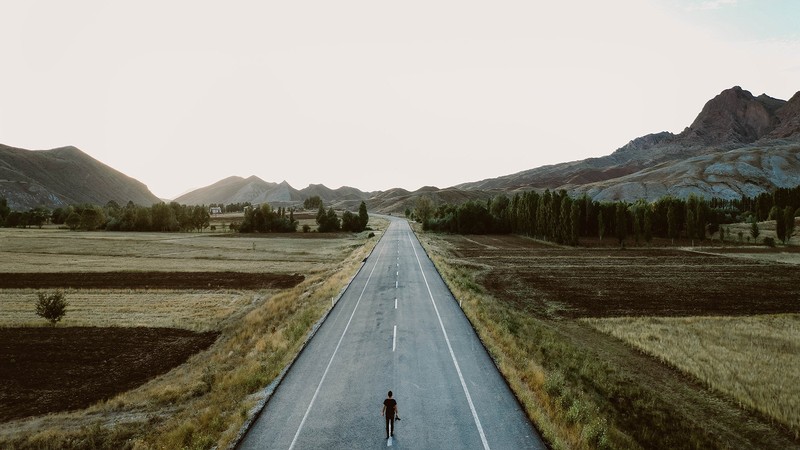 person standing on a wide-open road.