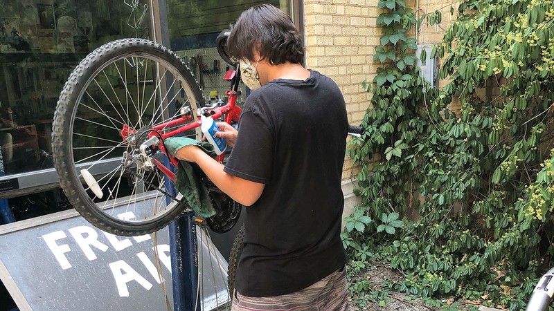Aggie Blue Bikes employee working on a bike.