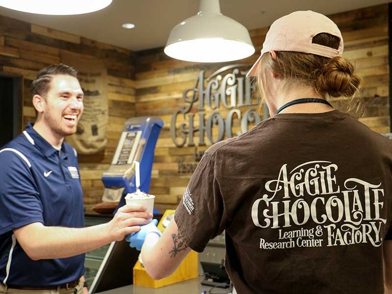 customer getting served chocolate at the Aggie Chocolate Factory.