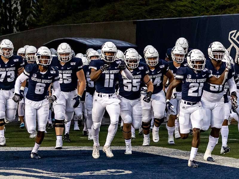 Aggie football players running onto the football field