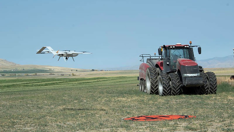 Aggie Air's newest aircraft—GreatBlue flies next to a tractor.