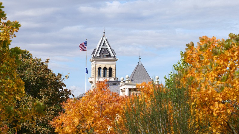 Old main with fall leaves in the background.