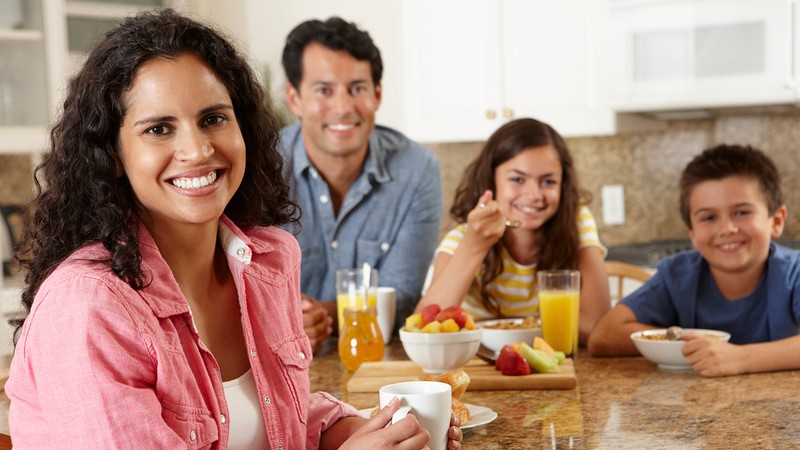 Family around the table having breakfast together.