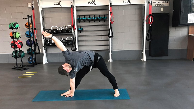 man doing a yoga pose in a gym.