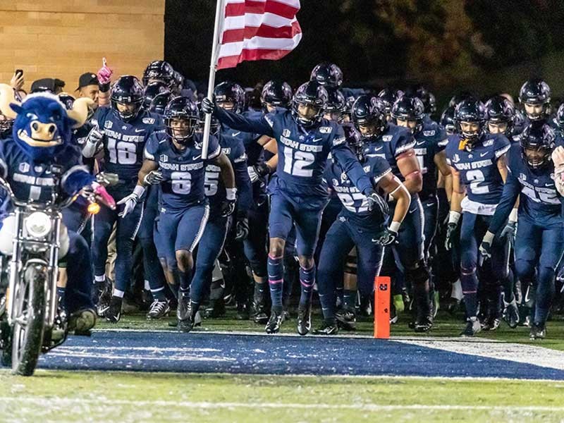 Aggie football players running onto the field