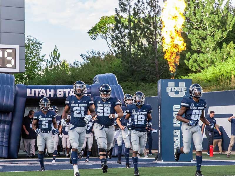 USU football players running out of the gate