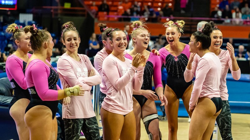 USU gymnasts gather on the floor at Dee Glen Smith Spectrum.