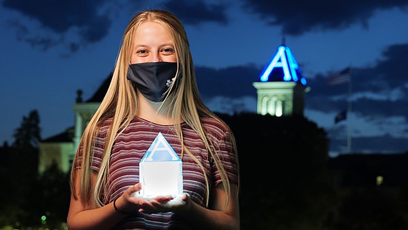 USU student holding a luminary with the 