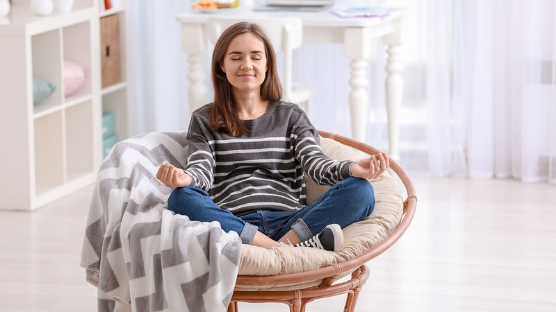 woman meditating in a chair.