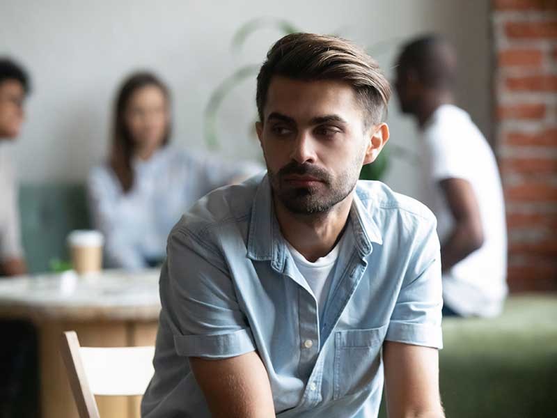 man sitting apart from others