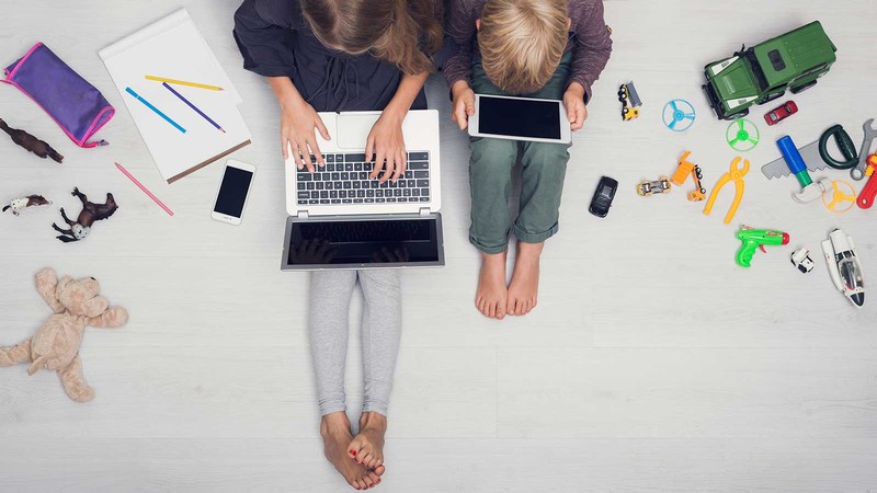 mother and child sitting next to a laptop computer.